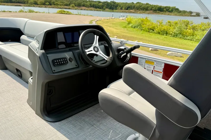 Slide: The Image of 2026 Sun Tracker SportFish 22 DLX boat interior with steering wheel and seating. - 14
