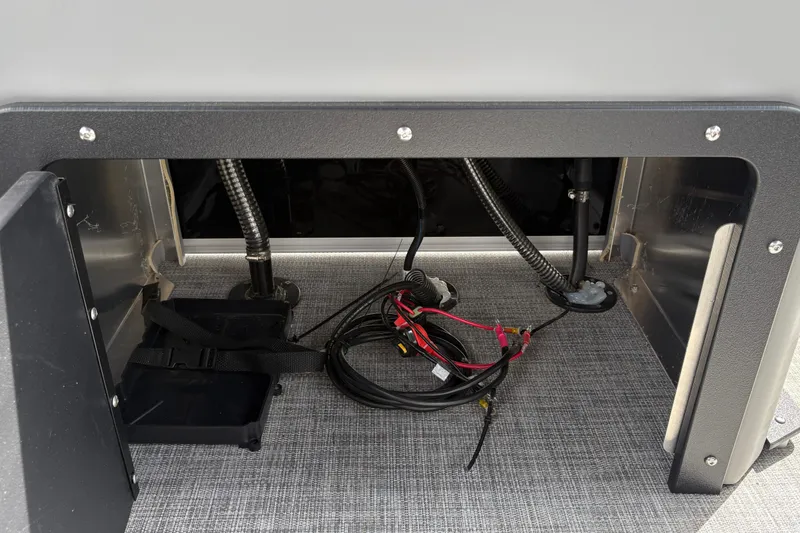 Slide: The Image of 2026 Sun Tracker SportFish 22 DLX storage compartment with wiring and straps. - 38
