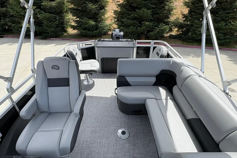 Slide: The Image of 2026 Sun Tracker SportFish 22 DLX pontoon boat interior with gray seating and helm. - 15