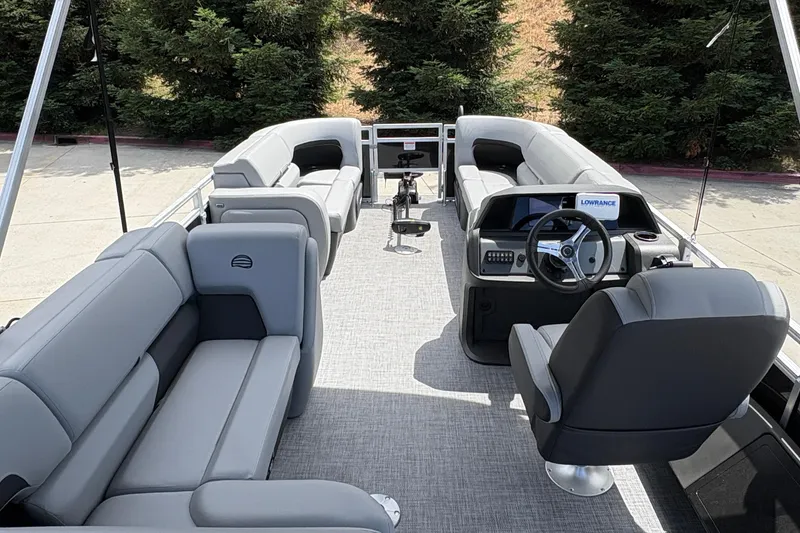 Slide: The Image of 2026 Sun Tracker SportFish 22 DLX pontoon boat interior with gray seating and steering console. - 13