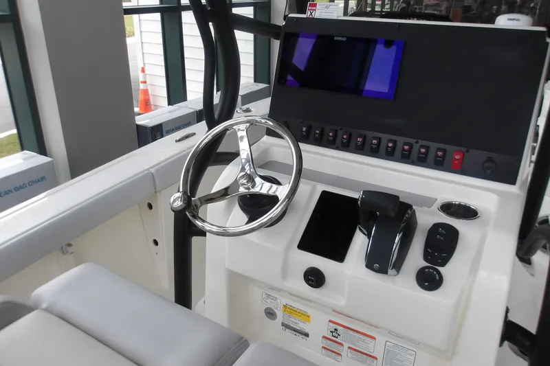 Slide: The Image of 2026 Mako 226 Center Console boat dashboard with steering wheel and control panel. - 30