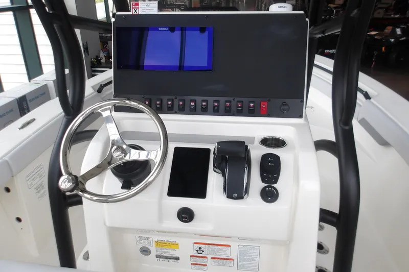 Slide: The Image of 2026 Mako 226 Center Console boat dashboard with steering wheel and control panel. - 31