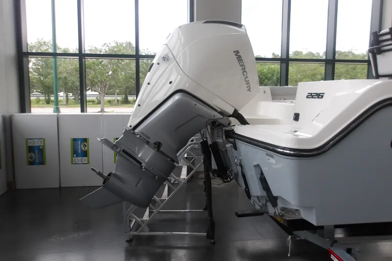 Slide: The Image of 2026 Mako 226 Center Console boat with Mercury outboard motor displayed indoors. - 37
