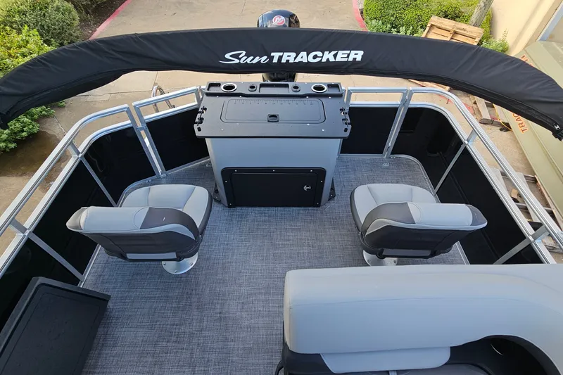 Slide: The Image of 2026 Sun Tracker SportFish 22 DLX pontoon boat interior with seating and helm station. - 12