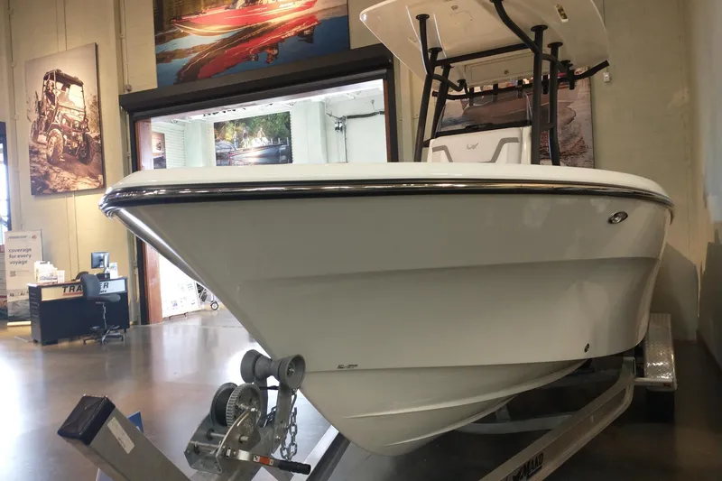 Slide: The Image of 2026 Mako 226 Center Console boat displayed indoors on a trailer. - 3