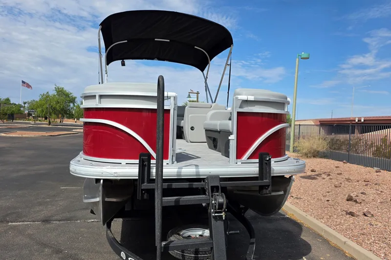 Slide: The Image of 2026 Sun Tracker SportFish 22 DLX pontoon boat with red exterior and black canopy. - 3