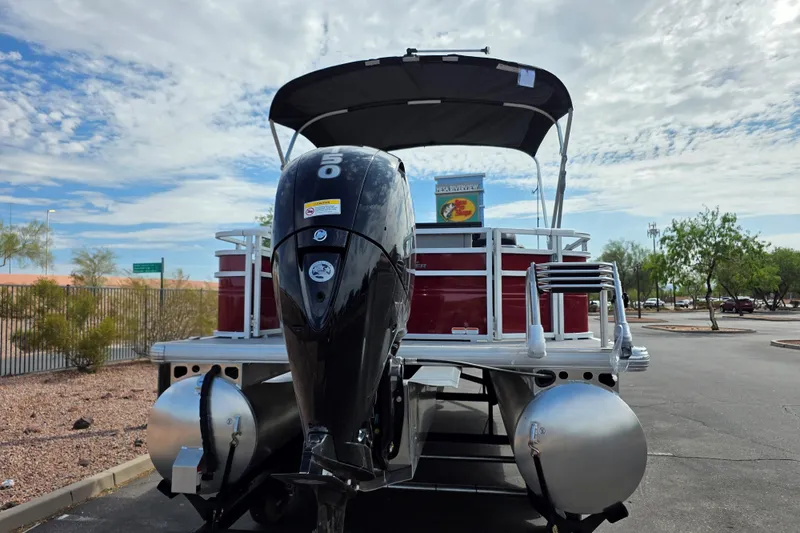 Slide: The Image of 2026 Sun Tracker SportFish 22 DLX pontoon boat with powerful outboard motor in a parking lot. - 4