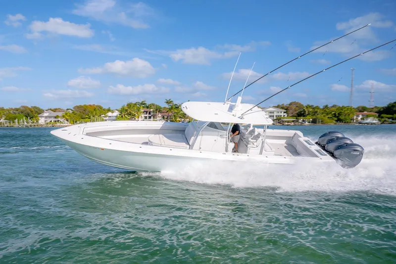 Slide: The Image of 2020 Contender 44 ST boat cruising on water with triple outboard engines. - 2