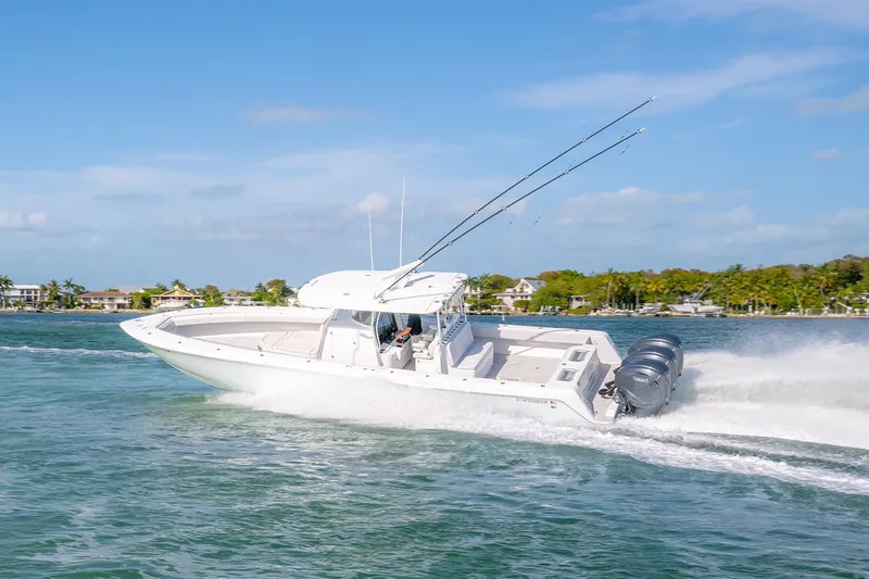 Slide: The Image of 2020 Contender 44 ST boat cruising on a sunny day with palm trees in the background. - 25