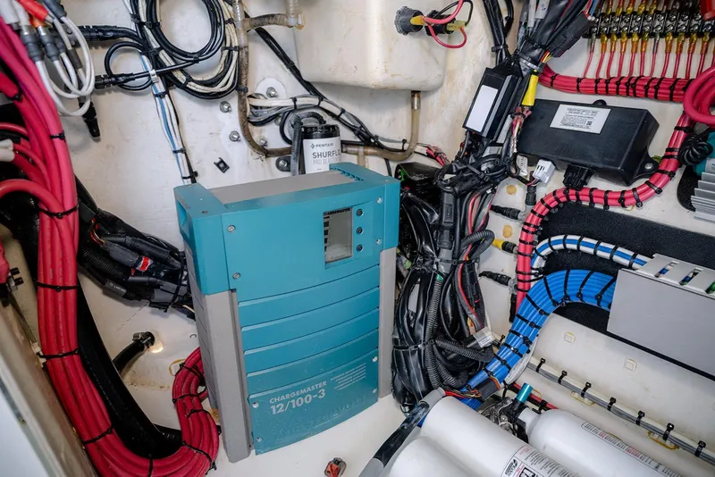 Slide: The Image of Electrical system inside a 2020 Contender 44 ST boat, featuring wiring and a battery charger. - 42