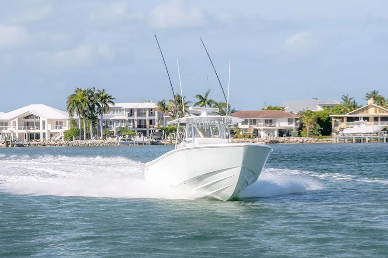 Slide: The Image of 2020 Contender 44 ST boat cruising near waterfront homes and palm trees. - 50