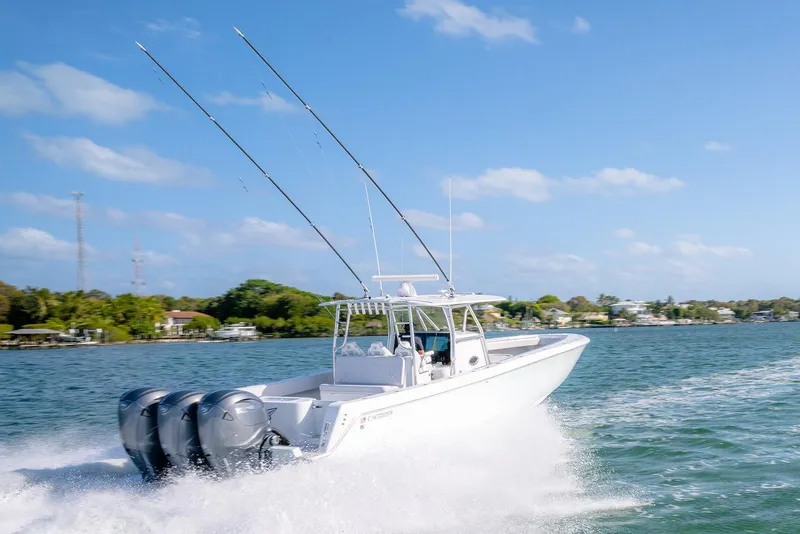Slide: The Image of 2020 Contender 44 ST boat cruising on a sunny day with triple outboard engines. - 51