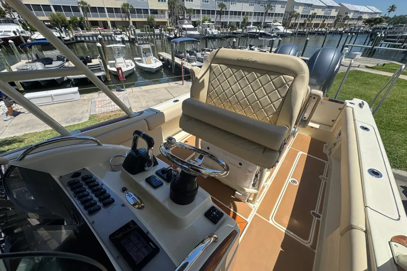 Slide: The Image of 2015 Chris-Craft Catalina 26 boat interior with helm, luxurious seating, and marina view. - 8