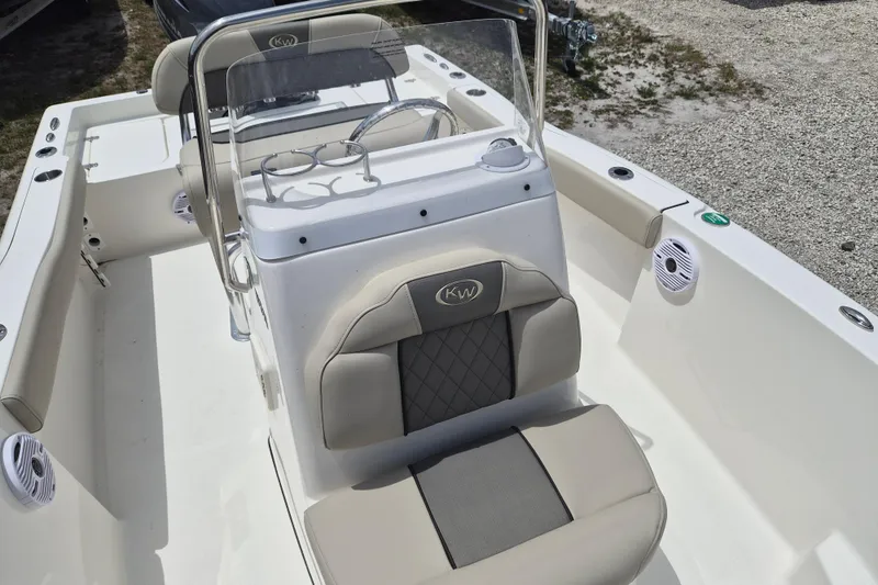Slide: The Image of 2026 Key West 179 FS boat interior with cushioned seating and steering console. - 12