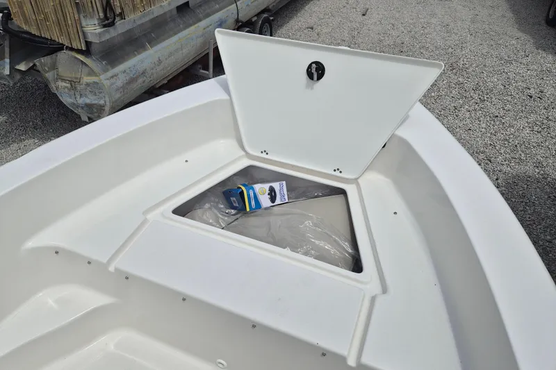 Slide: The Image of Open storage compartment on 2026 Key West 179 FS boat, containing packaged items. - 13