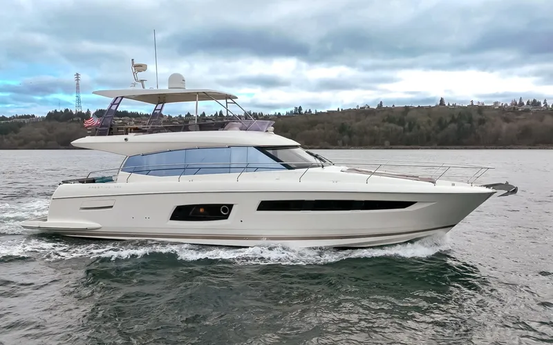 Slide: The Image of Prestige 560 yacht cruising under a bridge at sunset, 2017 model. - 4
