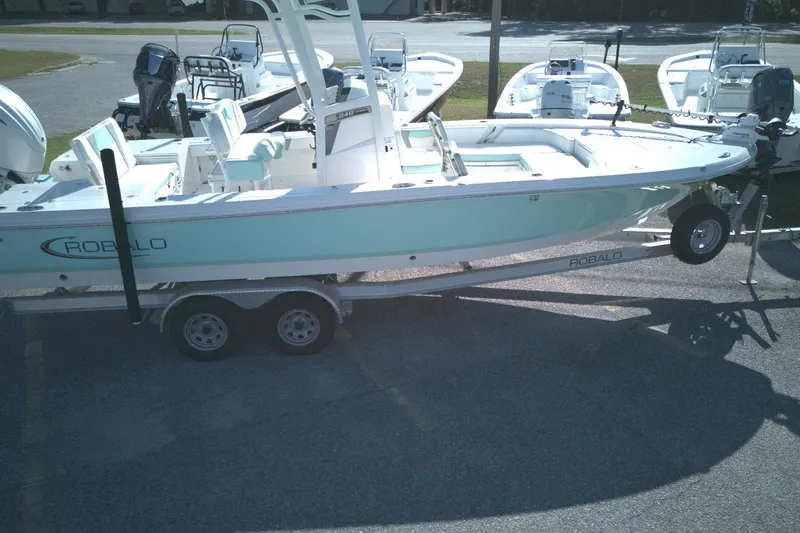 Slide: The Image of 2024 Robalo 246 Cayman boat on trailer, parked in a lot with other boats. - 10