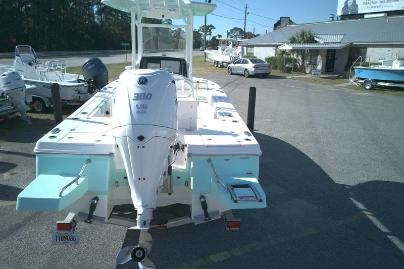 Slide: The Image of 2024 Robalo 246 Cayman boat with Yamaha 300 V6 engine, parked outdoors. - 2