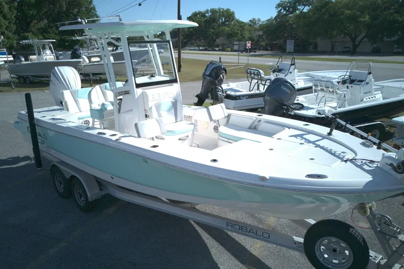 Slide: The Image of 2024 Robalo 246 Cayman boat on trailer, displayed outdoors with other boats. - 4