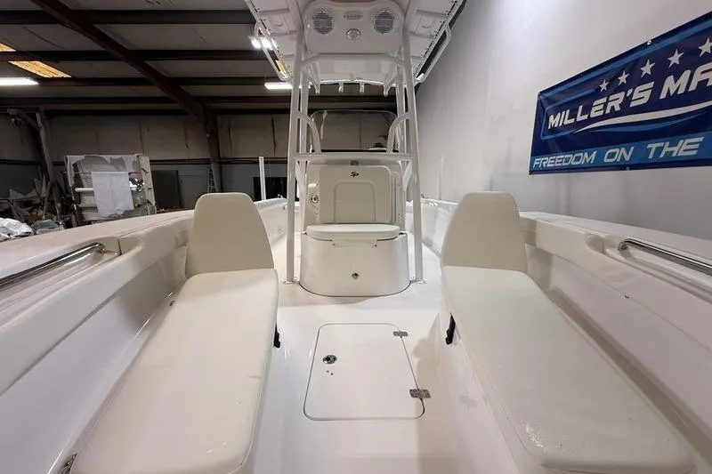 Slide: The Image of 2026 Sea Pro 202 Center Console boat interior with seating and storage in a showroom. - 15