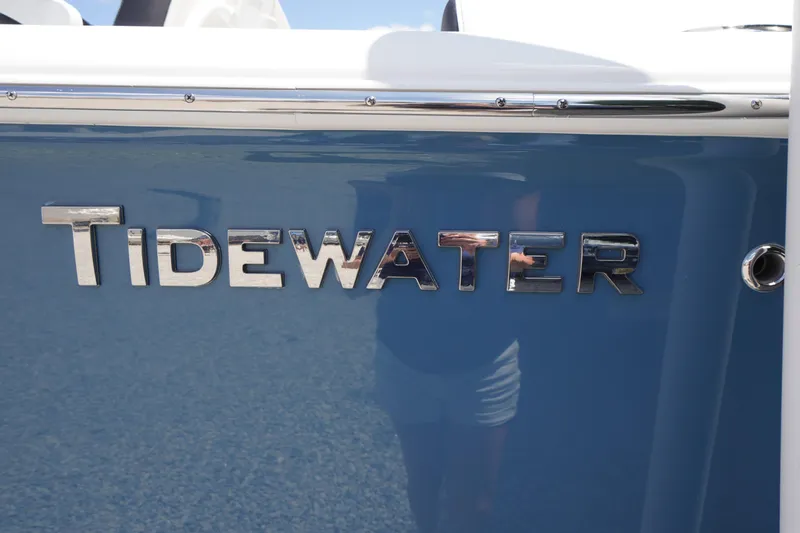 Slide: The Image of 2026 Tidewater 232 LXF boat with chrome logo on blue hull. - 2