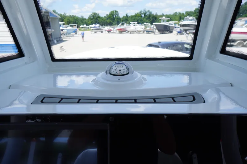 Slide: The Image of Interior view of 2026 Tidewater 232 LXF boat dashboard with compass and controls. - 27