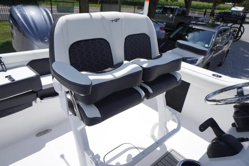Slide: The Image of 2026 Tidewater 232 LXF boat seating with dual cushioned chairs and steering wheel. - 39