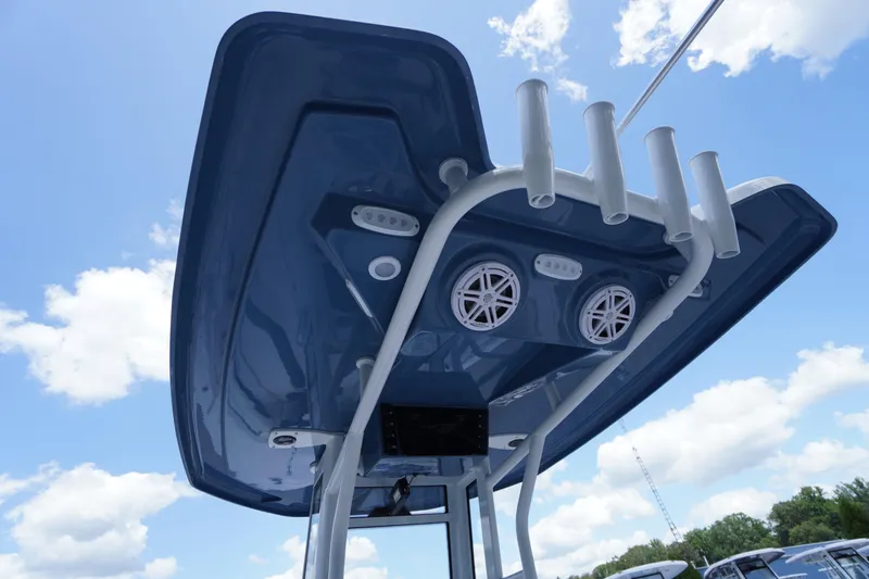 Slide: The Image of 2026 Tidewater 232 LXF boat T-top with speakers and rod holders against blue sky. - 59