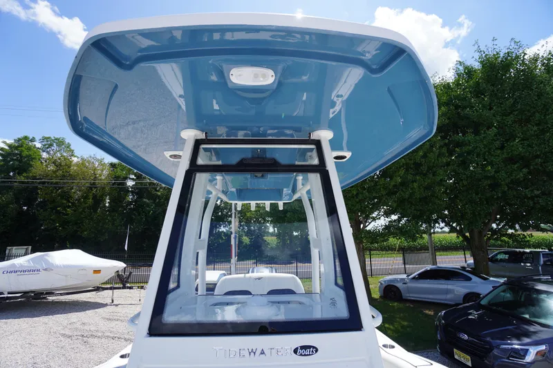 Slide: The Image of 2026 Tidewater 232 LXF boat with blue T-top, parked outdoors under clear sky. - 66