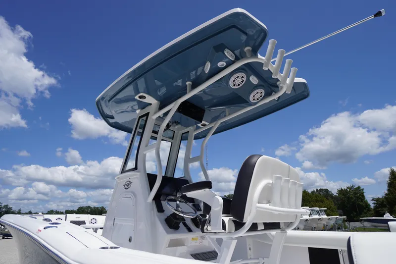 Slide: The Image of 2026 Tidewater 232 LXF boat with T-top and seating, under a clear blue sky. - 67