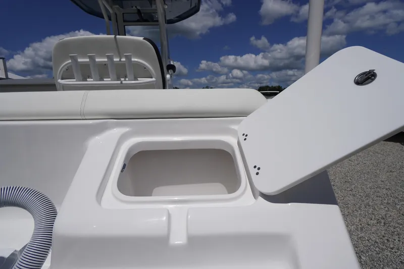 Slide: The Image of 2026 Tidewater 232 LXF boat with open storage compartment under clear blue sky. - 70