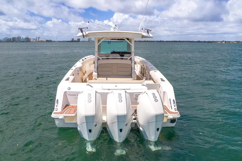 Slide: The Image of 2020 Boston Whaler 380 Outrage boat with triple engines on open water. - 11
