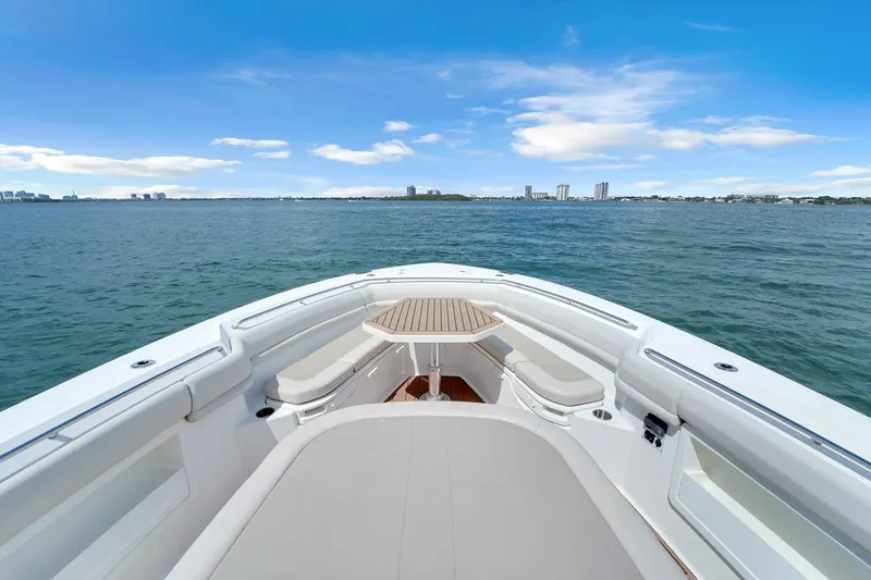 Slide: The Image of 2020 Boston Whaler 380 Outrage boat on open water, featuring spacious seating and a clear sky. - 19