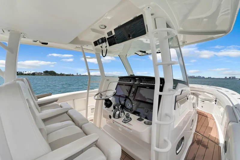 Slide: The Image of 2020 Boston Whaler 380 Outrage helm with advanced navigation systems, overlooking serene waters. - 34