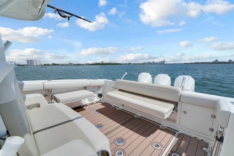 Slide: The Image of 2020 Boston Whaler 380 Outrage boat interior with seating, overlooking calm waters and city skyline. - 40
