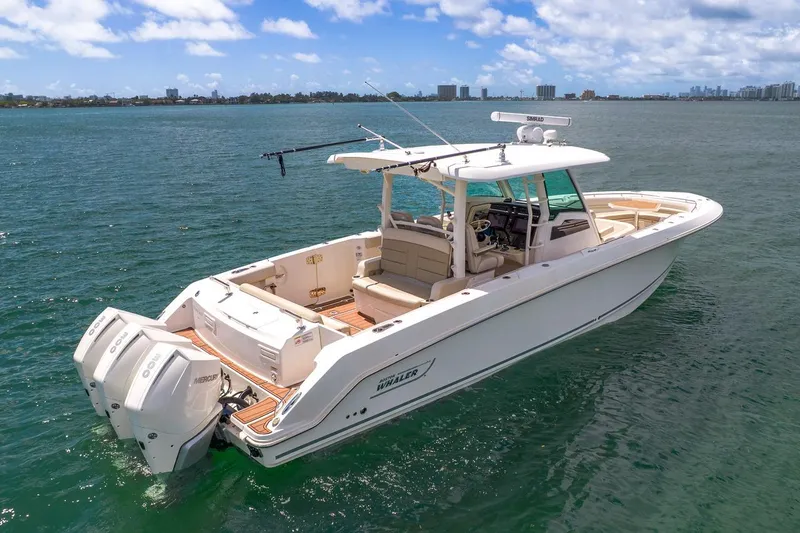 Slide: The Image of 2020 Boston Whaler 380 Outrage boat on open water, showcasing sleek design and powerful engines. - 5
