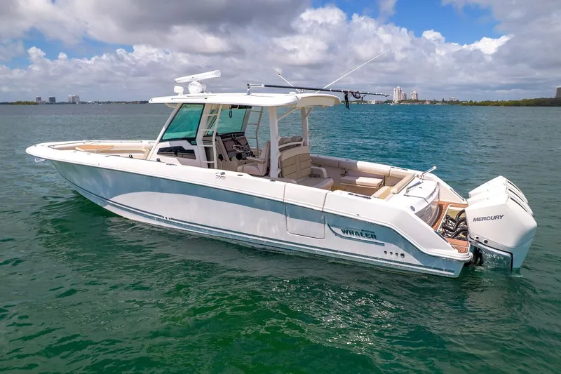 Slide: The Image of 2020 Boston Whaler 380 Outrage boat on calm water under a partly cloudy sky. - 8