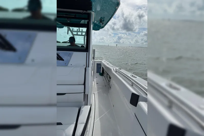 Slide: The Image of 2021 Blackfin 272 CC boat cruising on open water under a cloudy sky. - 15