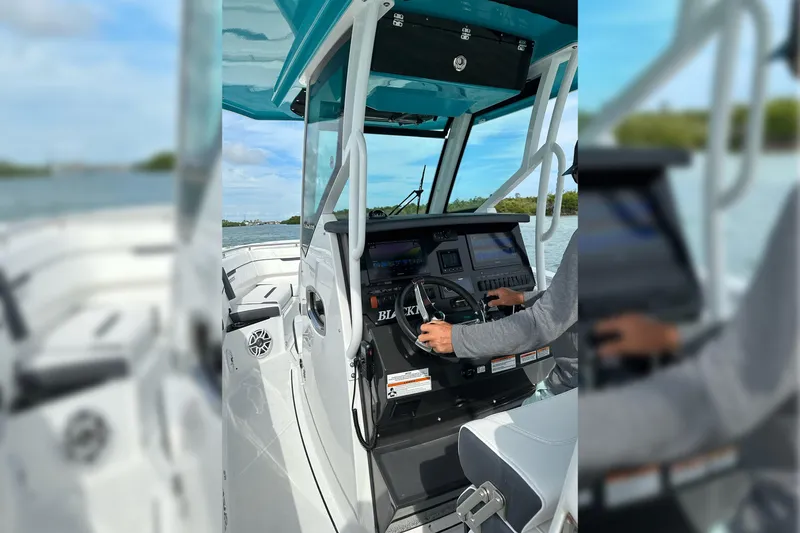Slide: The Image of 2021 Blackfin 272 CC boat dashboard with steering wheel and navigation controls. - 19