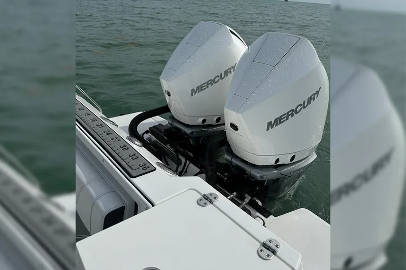 Slide: The Image of Twin Mercury outboard engines on a 2021 Blackfin 272 CC boat in water. - 23
