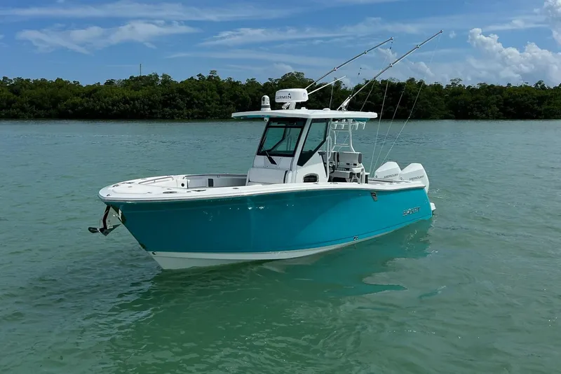 Slide: The Image of 2021 Blackfin 272 CC boat on calm turquoise water, equipped with fishing rods. - 3