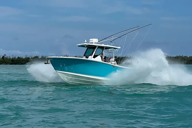 Slide: The Image of 2021 Blackfin 272 CC boat cruising on turquoise waters with splashing waves. - 7