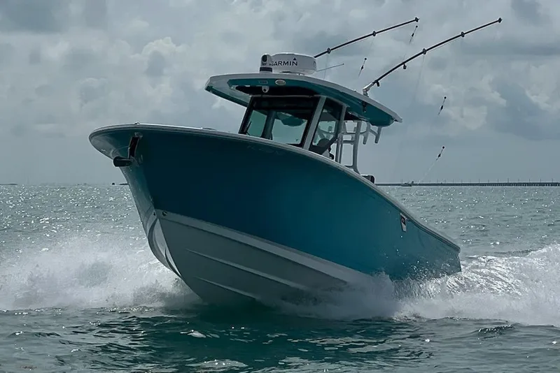 Slide: The Image of 2021 Blackfin 272 CC boat cruising on open water with fishing rods. - 8