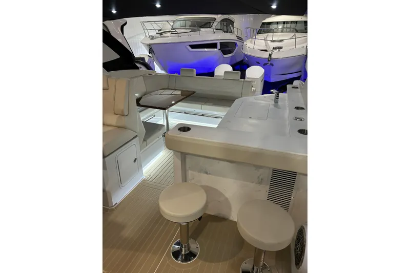 Slide: The Image of 2024 Cruisers Yachts 42 GLS OB interior with seating and bar stools in a showroom. - 13