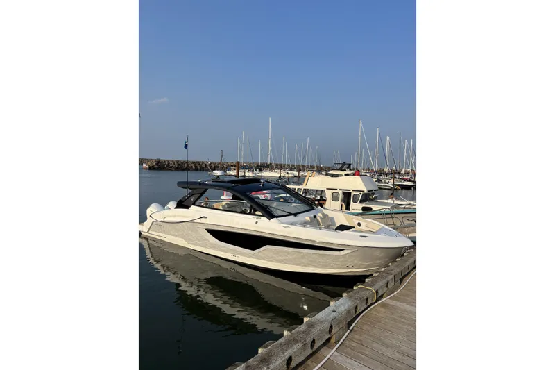 Slide: The Image of 2024 Cruisers Yachts 42 GLS OB docked at marina under clear blue sky. - 4