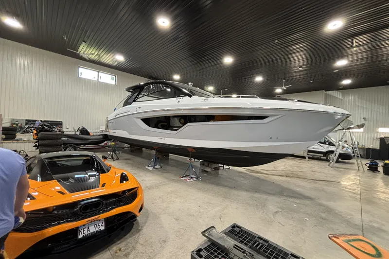 Slide: The Image of 2024 Cruisers Yachts 42 GLS OB in a garage with an orange sports car. - 8