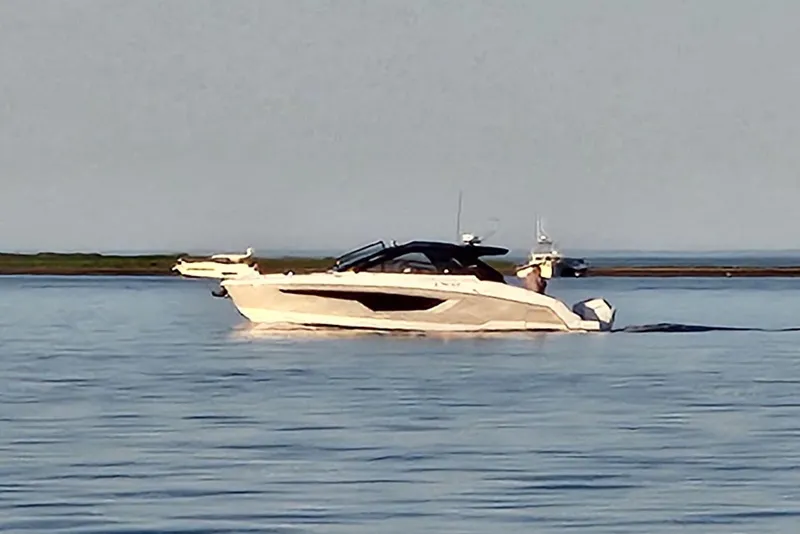 Slide: The Image of 2024 Cruisers Yachts 42 GLS OB on calm water, side view. - 1