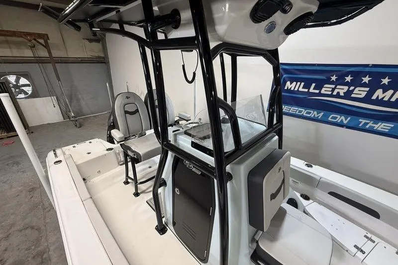 Slide: The Image of 2026 Sea Pro 202 Center Console boat interior with seating and control panel in a showroom. - 20