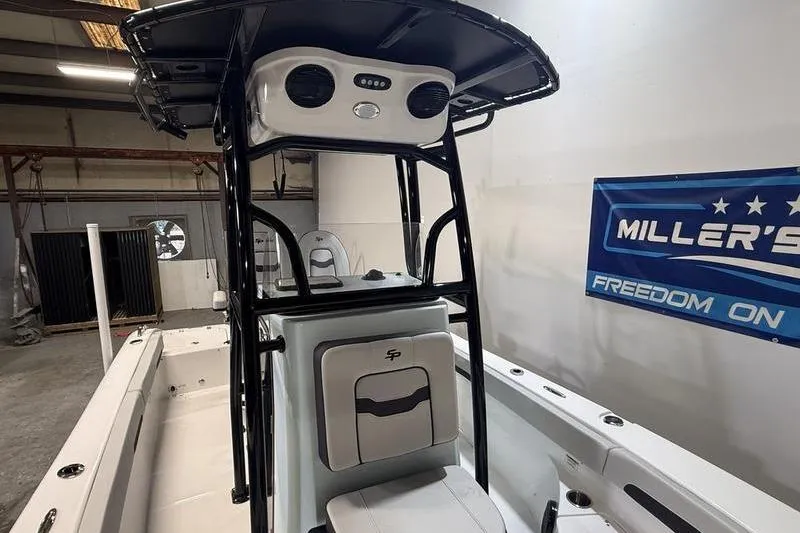 Slide: The Image of 2026 Sea Pro 202 Center Console boat interior with T-top and seating in a showroom. - 23