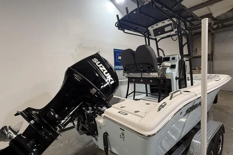 Slide: The Image of 2026 Sea Pro 202 Center Console boat with Suzuki outboard motor in a garage. - 4